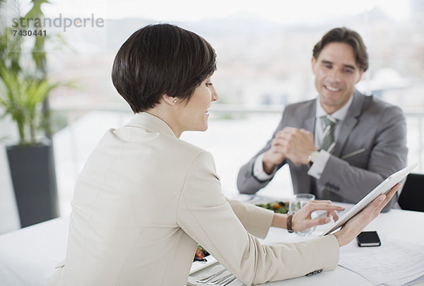Geschäftsmann und Geschäftsfrau mit digitalem Tablett am Restauranttisch