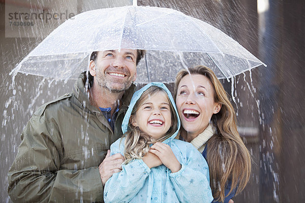 Enthusiastische Familie im Regenschauer