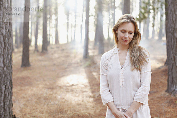 Porträt einer ruhigen Frau in sonnigen Wäldern