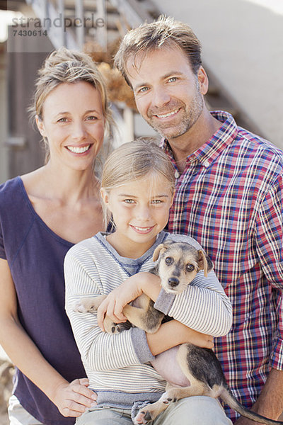 Porträt einer lächelnden Familie mit Welpe