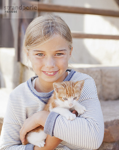 Porträt eines lächelnden Mädchens mit Kätzchen