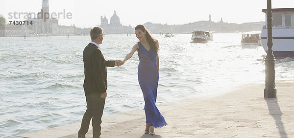 Gut gekleideter Mann und Frau am Wasser in Venedig