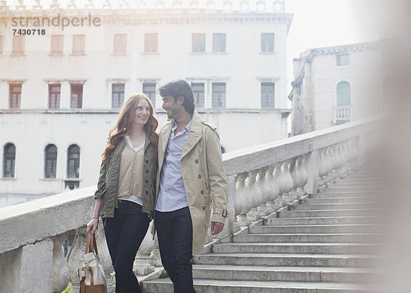 Lächelndes Paar beim Treppensteigen in Venedig
