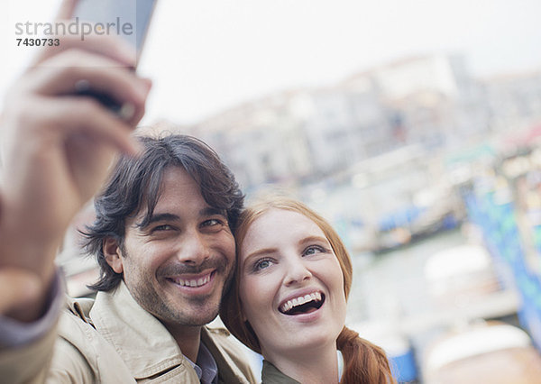 Lächelndes Paar beim Selbstporträt mit Handy