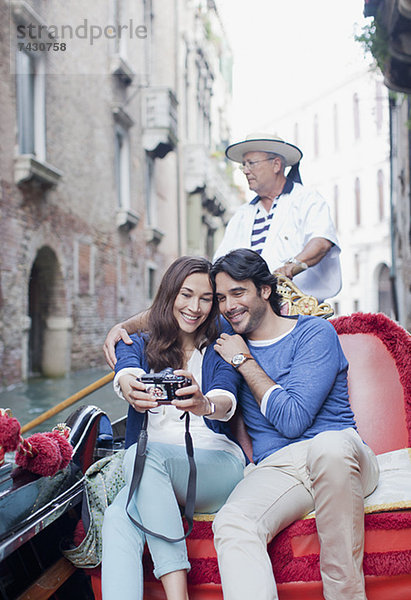Lächelndes Paar beim Selbstporträt mit Digitalkamera in der Gondel auf dem Kanal in Venedig