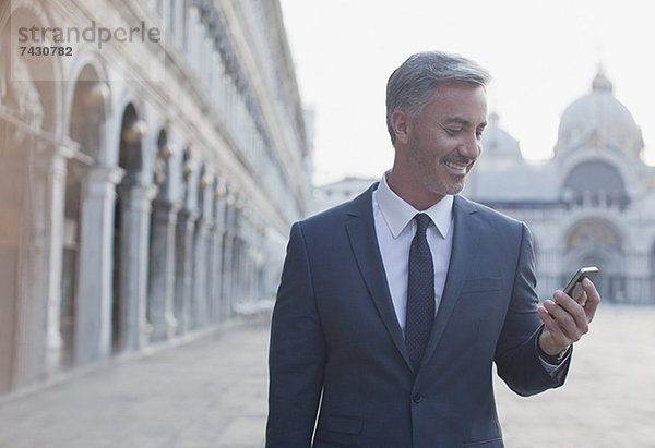 Lächelnder Geschäftsmann beim Telefonieren auf dem Markusplatz in Venedig