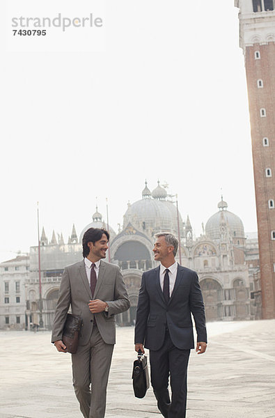Lächelnde Geschäftsleute auf dem Markusplatz in Venedig