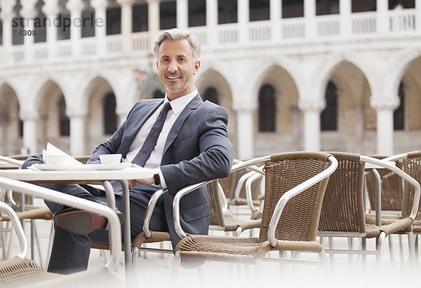 Porträt eines lächelnden Geschäftsmannes im Straßencafé in Venedig