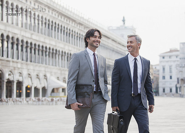 Lächelnde Geschäftsleute gehen über den Markusplatz in Venedig