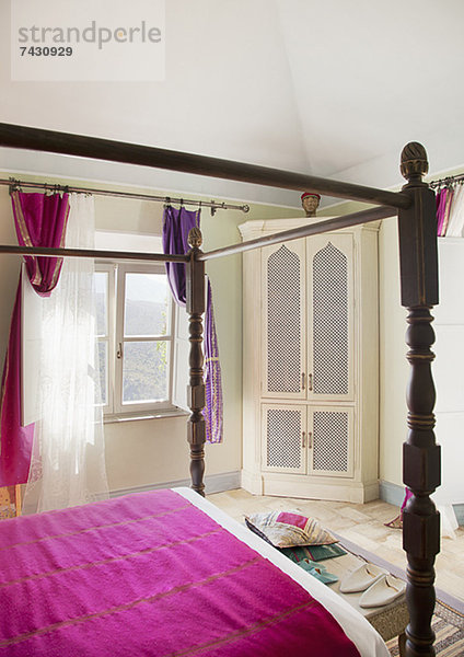 Himmelbett mit violetter Bettwäsche im Schlafzimmer