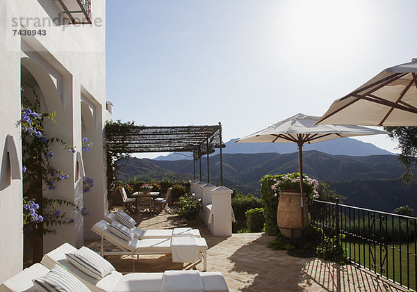 Liegestühle und Sonnenschirme auf dem Balkon des Luxushotels