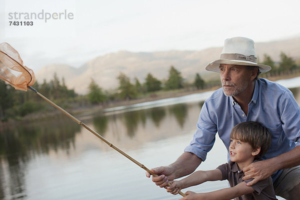 Großvater und Enkel fischen am See