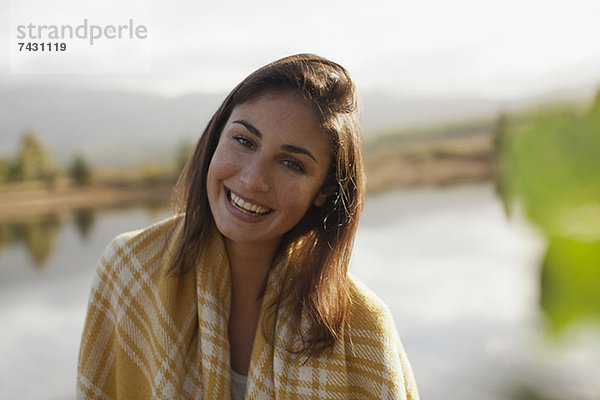 Porträt einer lächelnden Frau am Seeufer