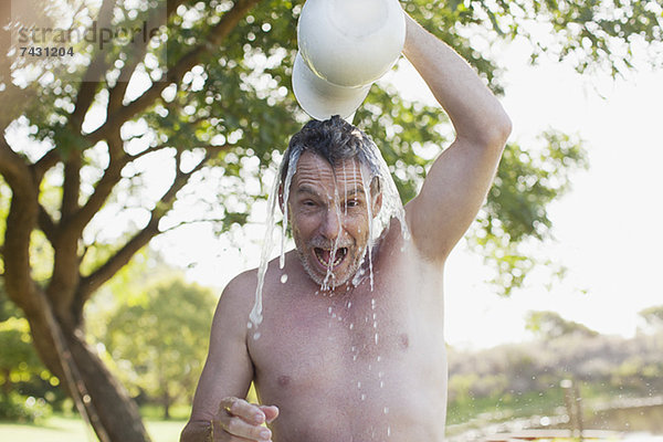 Porträt eines begeisterten Mannes  der Wasser über uns gießt.