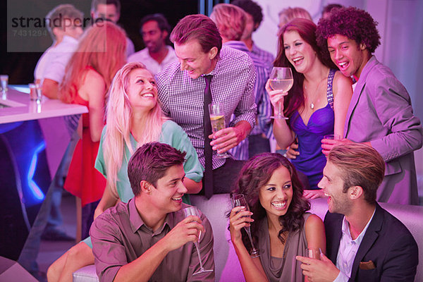 Lächelnde Freunde trinken Champagner im Nachtclub