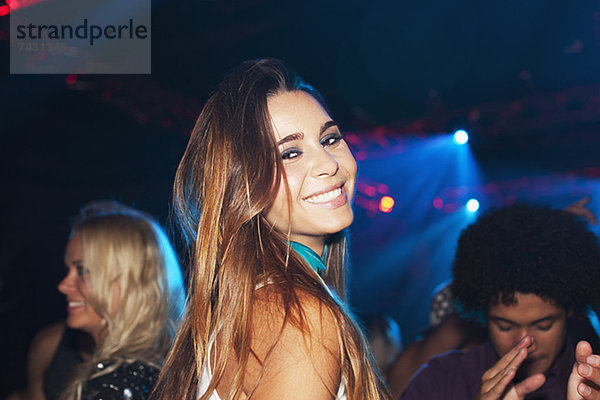 Porträt der lächelnden Frau auf der Tanzfläche des Nachtclubs
