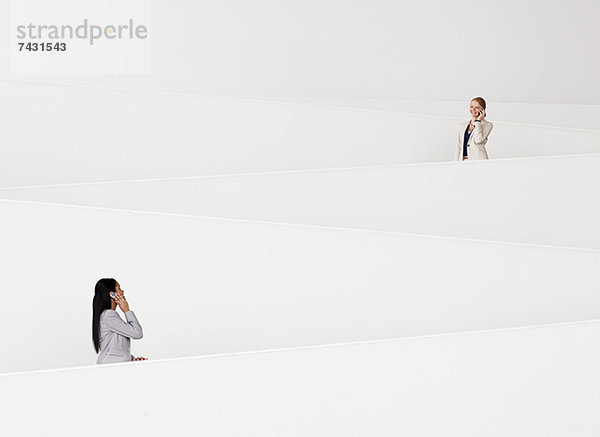 Geschäftsfrauen im Gespräch mit dem Handy auf der modernen Treppe