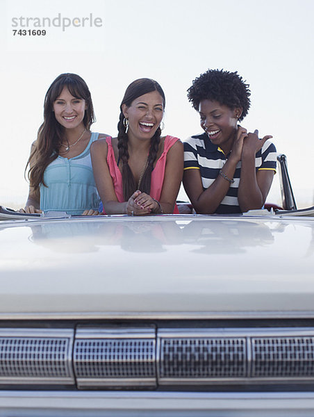 Lächelnde Frauen sitzen im Cabriolet