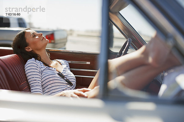 Lächelnde Frau entspannt im Cabriolet