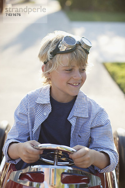 Lächelnder Junge spielt im Go-Cart