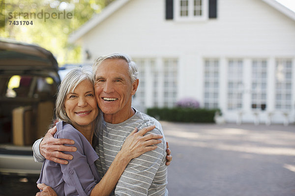 Lächelndes älteres Paar  das sich im Freien umarmt.