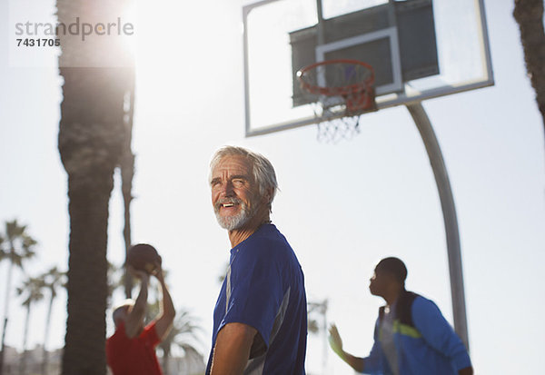 Ältere Männer spielen Basketball auf dem Platz