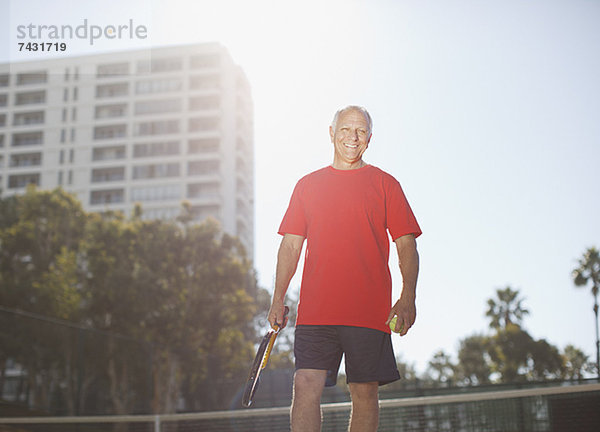 Älterer Mann beim Tennisspielen auf dem Platz