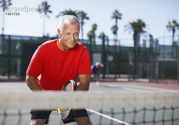 Älterer Mann beim Tennisspielen auf dem Platz