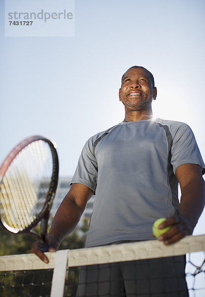 Älterer Mann beim Tennisspielen auf dem Platz