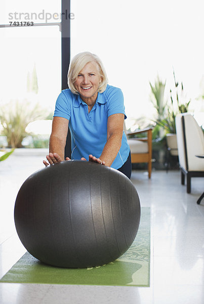 Ältere Frau mit Übungsball zu Hause