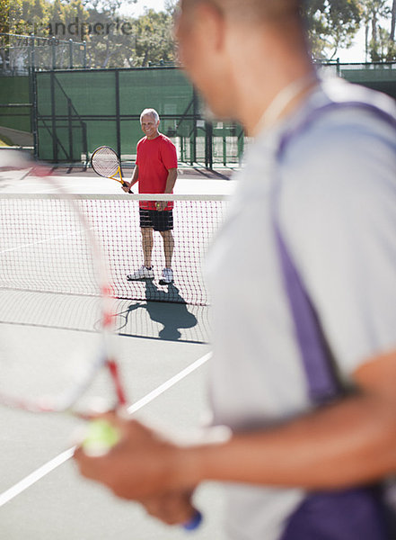 Ältere Männer beim Tennisspielen auf dem Platz