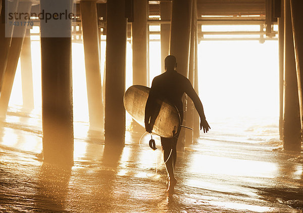 Älteres Surfer-Tragebrett unter dem Pier