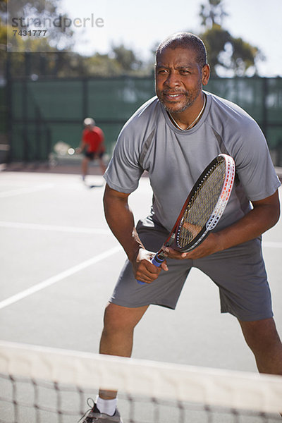 Älterer Mann beim Tennisspielen auf dem Platz