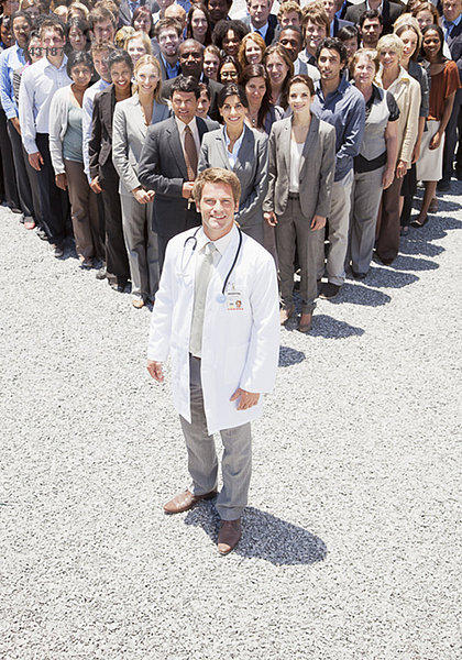 Porträt eines selbstbewussten Arztes mit Geschäftsleuten im Hintergrund