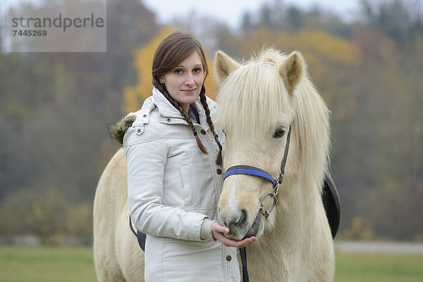 Lächelnde junge Frau mit einem Pferd