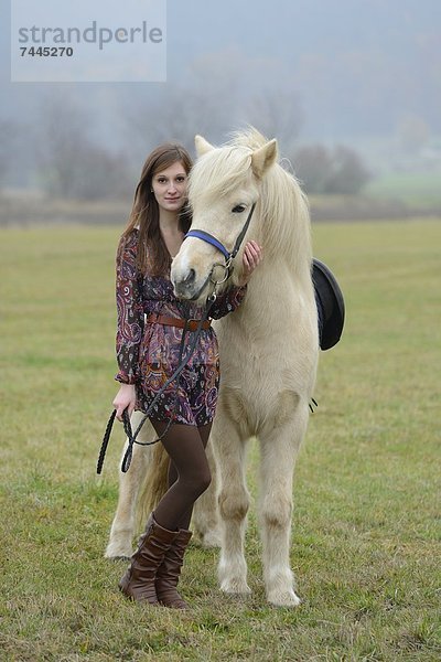 Lächelnde junge Frau mit einem Pferd