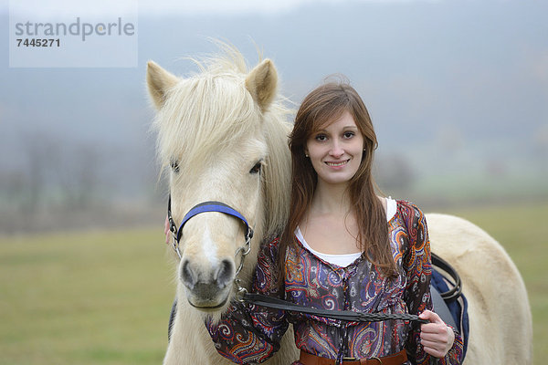 Lächelnde junge Frau mit einem Pferd