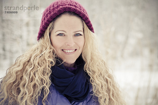 Blonde Frau in Winterkleidung im Freien  Portrait