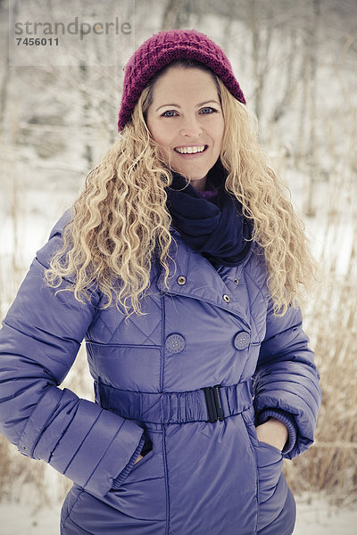 Blonde Frau in Winterkleidung im Freien