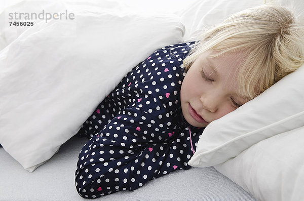 Mädchen liegt im Bett und schläft