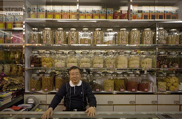 hinter  stehend  Mann  Blick in die Kamera  Lebensmittelladen  Laden  China  Asien  Tresen  Hongkong