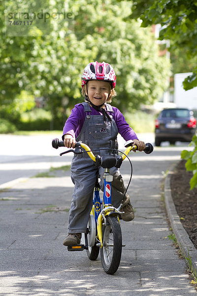 Fröhliches Kleinkind auf einem Fahrrad