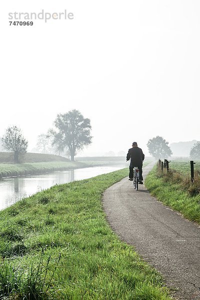 Europa  Mann  Ländliches Motiv  ländliche Motive  radfahren  Weg  Markierung  Fluss  Herbst  Breda