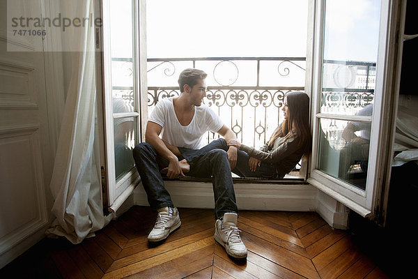 Paar auf der Fensterbank sitzend