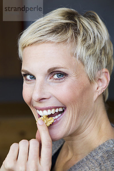 Lächelnde Frau isst Snack