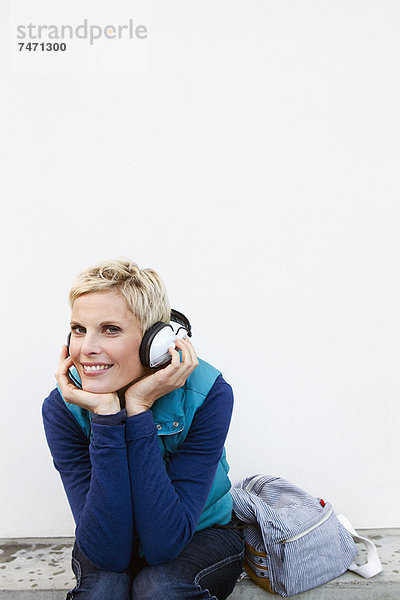 Lächelnde Frau beim Hören von Kopfhörern