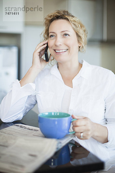 Frau mit Kaffee am Telefon