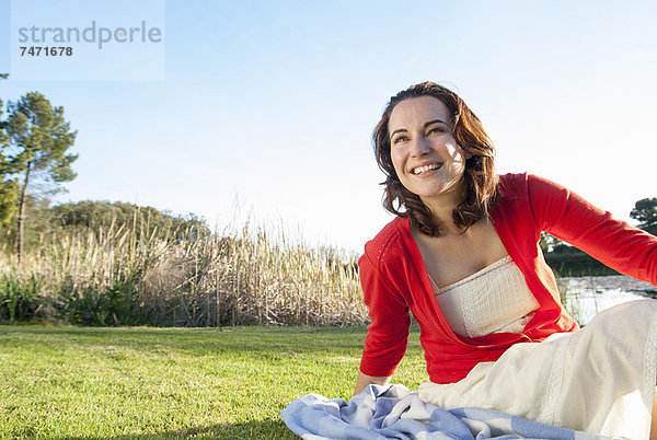 Frau sitzend im Gras im Park