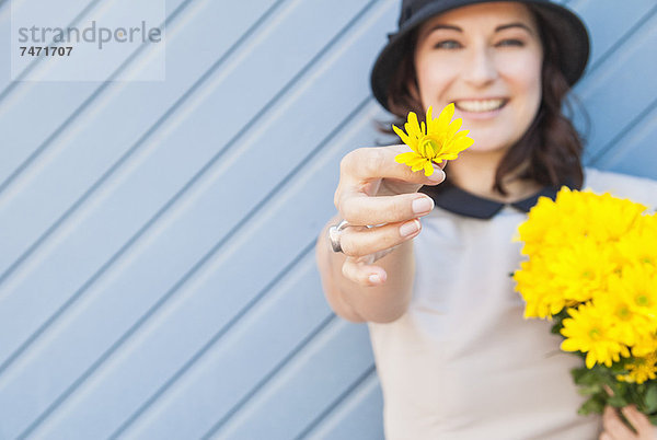 Frau mit gelber Blume im Freien
