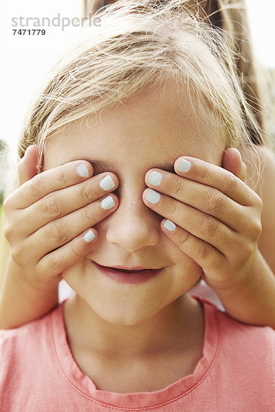 Mädchen  das die Augen eines Freundes bedeckt